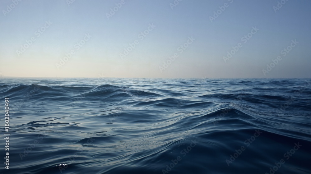 Fototapeta premium Endless expanse of ocean meets the pale horizon under the open sky.