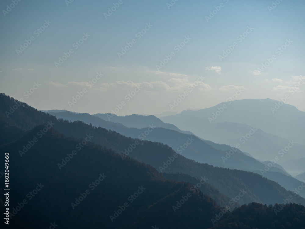 Fototapeta premium Silhouettes of a mountain range fading into the horizon. 