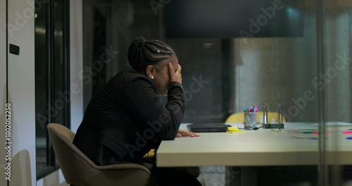 Billede på lærred African American businesswoman sits in silence at office table with hand over fa