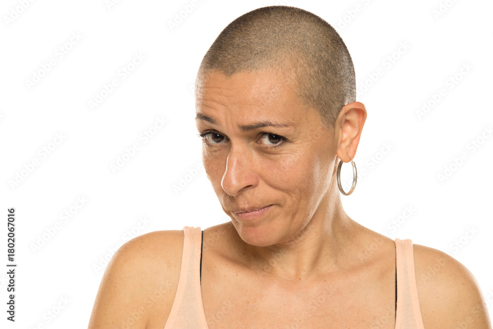 Fototapeta premium Studio shot of bald woman in tank top with skeptical and doubtful expression on white background.