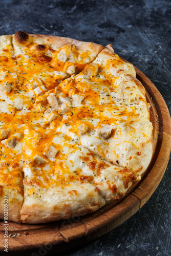 Cheesy Chicken Pizza On Wooden Board With Golden Crust And Melted Cheese