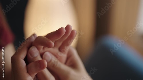 Man gently massaging woman hands, focusing on fingers and palm, conveying concepts of care, affection, intimacy, relaxation, and tenderness between loving couple, close-up. Shooting in slow motion.