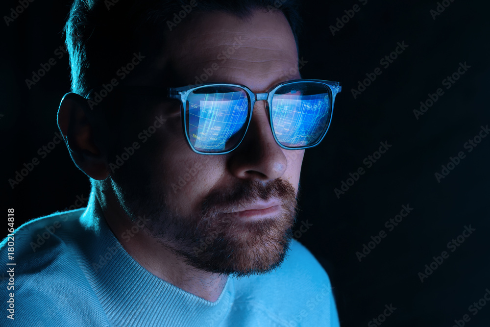 Obraz premium Man wearing glasses with reflection on black background, closeup. Space for text