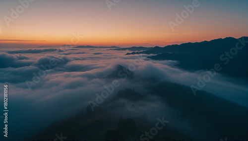Peaceful Dawn Over Misty Mountain Landscape with Soft Clouds and Warm–Cool Morning Horizon