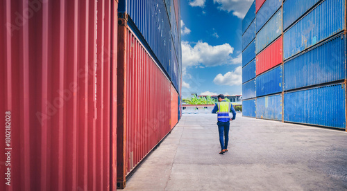 Portrait of Engineer or foreman wears PPE checking container storage with cargo container background at sunset. Logistics global import or export shipping industrial concept.