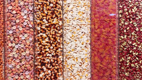 Colorful candies displayed in a sweet shop, neatly arranged in transparent containers. Bright pastel sweets symbolizing sugar, confectionery, and sugar-free treat concepts.