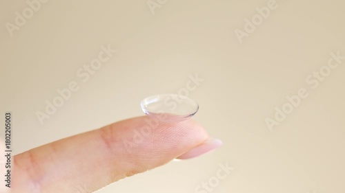 Close-up of a hand holding a soft contact lens on fingertip. Vision correction, eye care, and ophthalmology concept with daily disposable lens.