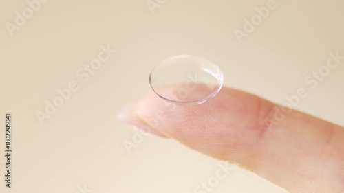 Close-up of a hand holding a soft contact lens on fingertip. Vision correction, eye care, and ophthalmology concept with daily disposable lens.