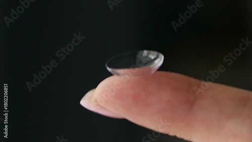 Close-up of a hand holding a soft contact lens on fingertip. Vision correction, eye care, and ophthalmology concept with daily disposable lens.