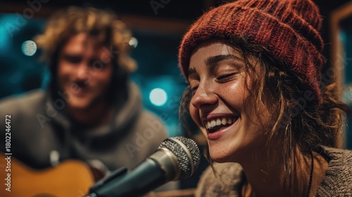 Two musicians working together in a recording studio, woman with glasses singing into microphone while man plays guitar, creative collaboration shown