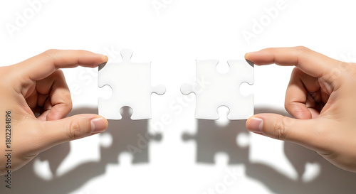 Hands holding two connecting puzzle pieces, symbolizing teamwork, solutions, and collaboration concepts.