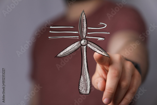 Hand pointing at a wind tur...
