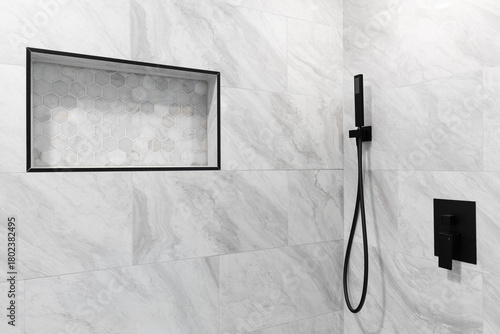 A bathroom shower detail with marble tile walls, black faucet, and a shelf with a hexagon tiled backsplash.