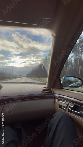 Vertical screen passenger filming from inside a beige car interior relaxed road vibe calm drive soft daylight passing scenery gentle motion peaceful travel atmosphere