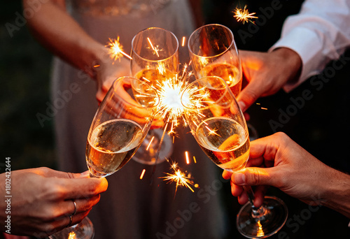 People toasting with champagne glasses and sparklers celebrating happy new year holiday and seasonal joy