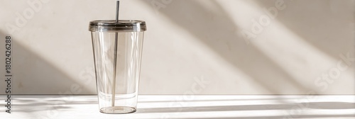 Clear Plastic Cup With Straw on Sunlit Table: Minimalist Takeout Drink Container for Everyday life, Modern Studio Shot Highlighting Light and Shadow