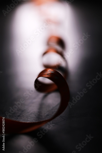 Canvastavla Elegant Curled Ribbon on Dark Surface with Dramatic Lighting in Focus