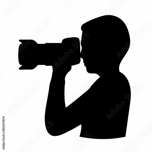 Silhouette of a photographer taking a picture with a large lens camera