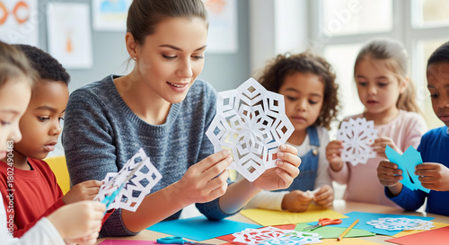Kindergarten teacher teaches children paper snowflakes, Christmas routine in kindergarten.