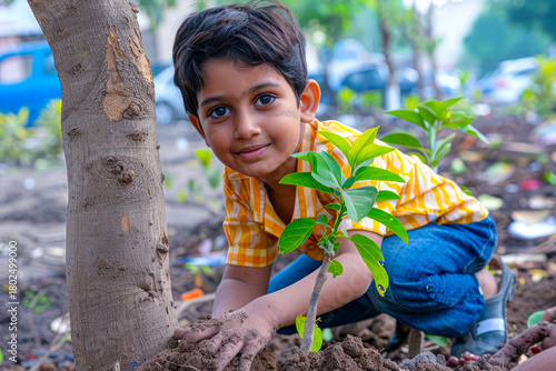 An Indian boy participating in a tree-planting drive in his neighborhood on Environment Day, greening urban spaces and improving air quality.