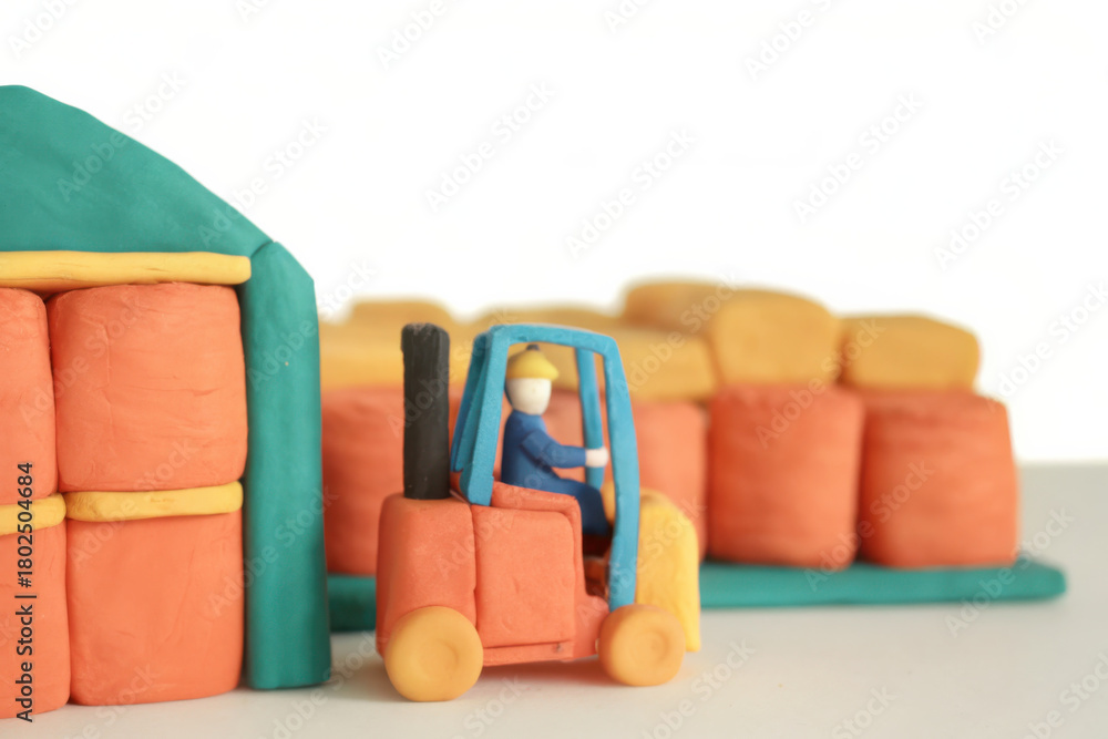 Naklejka premium Clay forklift with operator lifting load near clay packaging center with stacked clay blocks in warehouse