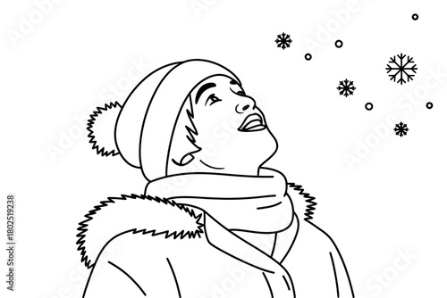 A person looks up at falling snowflakes during winter weather.