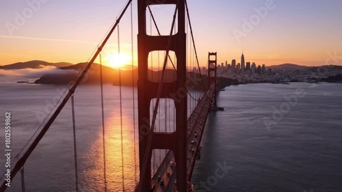 The Golden Gate Bridge stands majestically, its iconic structure silhouetted against a breathtaking sunrise over the tranquil waters, creating a stunning visual of travel and adventure.