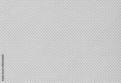 Gray paper with a pattern of small white polka dots arranged in a uniform grid. Minimalist design meant as background