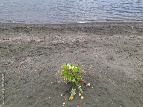 melancholic and lonely bunch of flowers abandoned on the shore of the winter lake