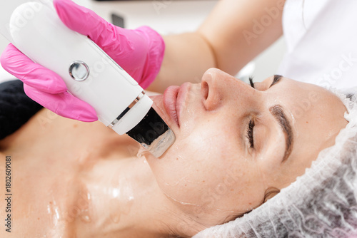 Photos Ultrasonic skin scrubber facial cleansing procedure in modern beauty clinic