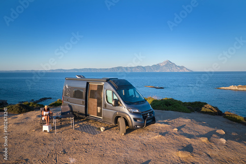 Camper van parked on a coastal cliff facing Mount Athos and the calm Aegean. Ideal for: vanlife travel, adventure brands, outdoor gear, road-trip blogs, tourism.