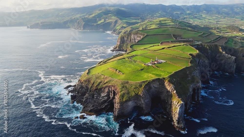 Aerial drone shot of Cape Cintrao with lighthouse on high cliff Atlantic ocean coast Sao Miguel island Azores