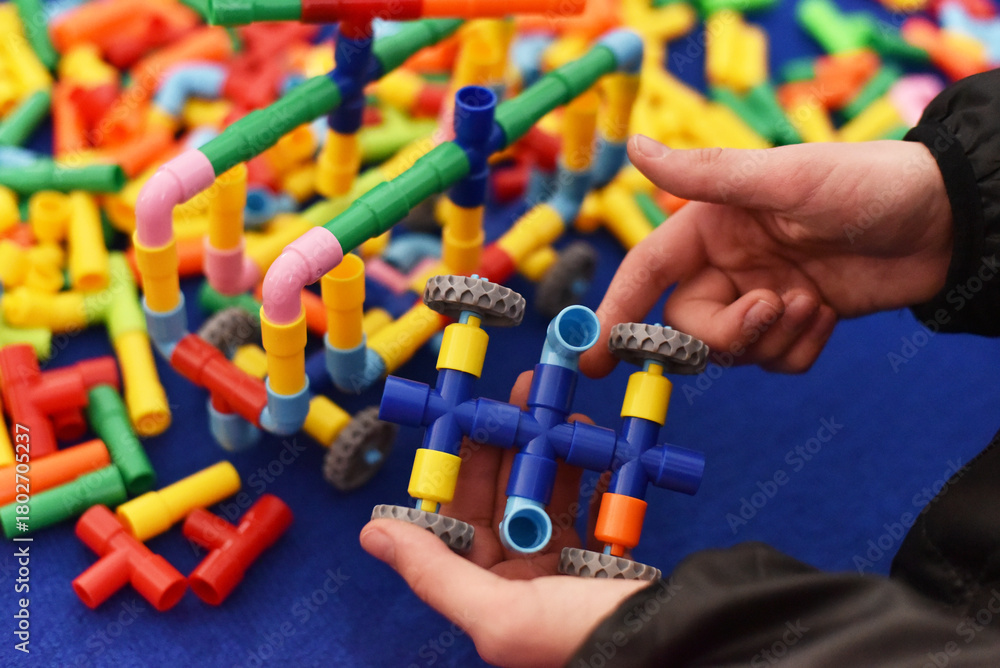 Naklejka premium The child is playing with a constructor.