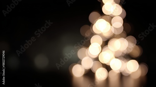 Soft shimmering Christmas tree lights glowing warmly against black background, dreamy bokeh effect