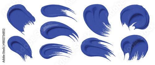 Set of Eight Textured, Energetic Paint Swipes in Various Shades of Blue, Capturing Fluid Motion Isolated strokes of blue paint on a white background.