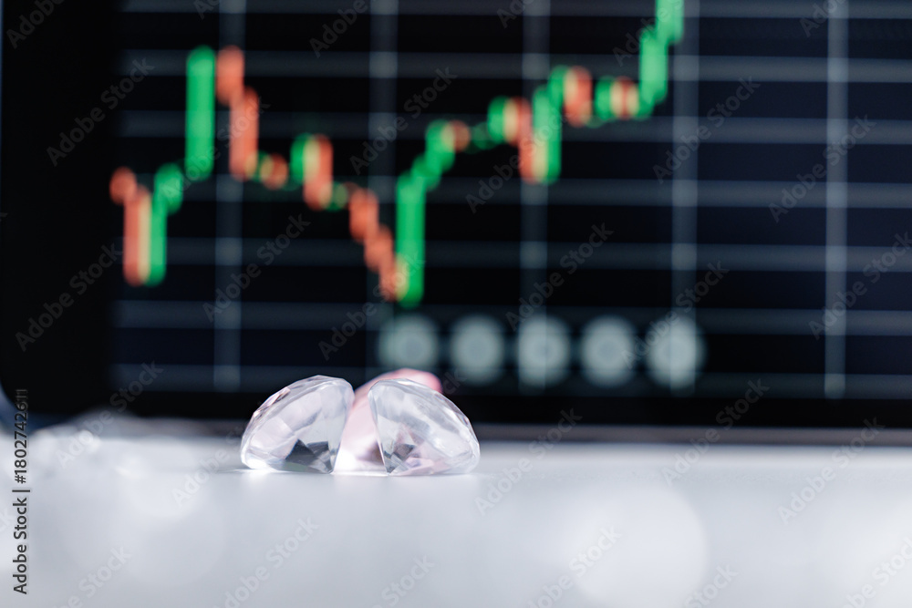 Naklejka premium Closeup of diamonds with blurred stock market graph in background