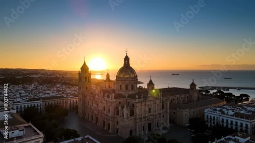 Aerial view of a beautiful cathedral with a golden dome and towers at sunset near the sea