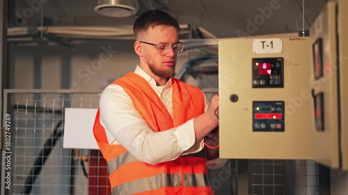 Professional engineer meticulously inspects industrial electrical panel. Multimeter used for precise measurements. Serious focus ensures system accuracy. Diligent work maintains safety standards.