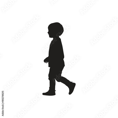 Silhouette of a young child walking with a slight forward lean against a white background in a studio shot