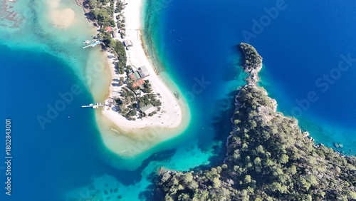 Fototapeta Naklejka Na Ścianę i Meble -  A drone view of the Ölüdeniz peninsula and its turquoise lagoon on the Mediterranean coast of Turkey, surrounded by forested mountains and clear blue water.