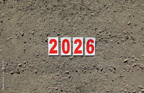 Numbers of 2026 year. Paper square numbers on the grey concrete background, that means coming New Year Eve. Christmas, holidays, celebration concept. New Year of 2026, year of the red fire horse