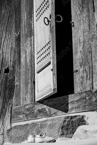 Old Wooden Temple Door with Shoes on Stone Step