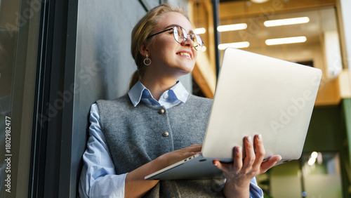 Young woman working on laptop in modern workspace