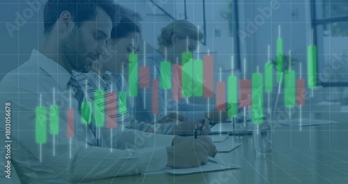 Writing team wearing business attire reviewing papers at meeting, using laptop with chart overlay