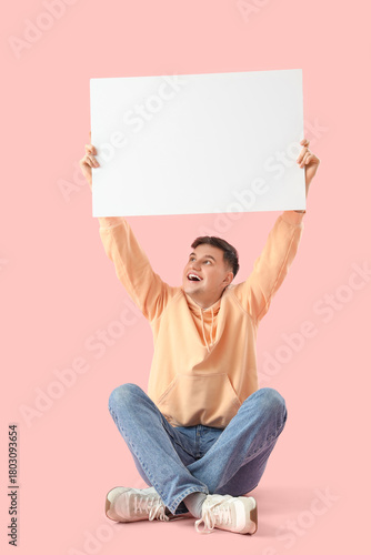 Young man with blank poster...