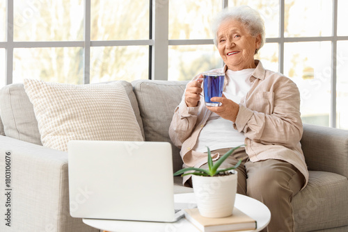 Senior woman with glass cup...