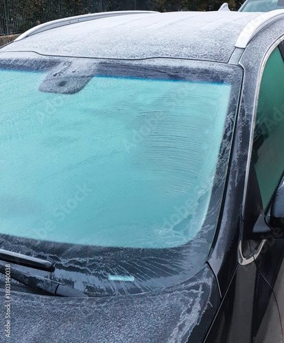Car windshield and roof covered in thick frost in winter