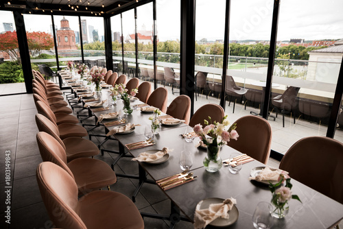 Принти на полотні Elegant rooftop event table setup with modern dining décor, floral centerpieces, and panoramic Vilnius city views, arranged for a stylish celebration, wedding reception, or upscale gathering