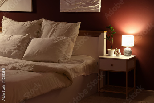 Tableau sur toile Glowing lamp with plant on nightstand in dark bedroom