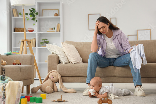 Fotografie Overwhelmed young mother experiencing parental burnout and stress with baby on f